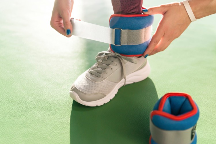 woman putting ankle weights before excercise